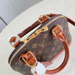 Louis Vuitton Alma BB M53152 Monogram canvas handbag with crocodile-embossed leather trim, Toron handles, padlock, and adjustable shoulder strap